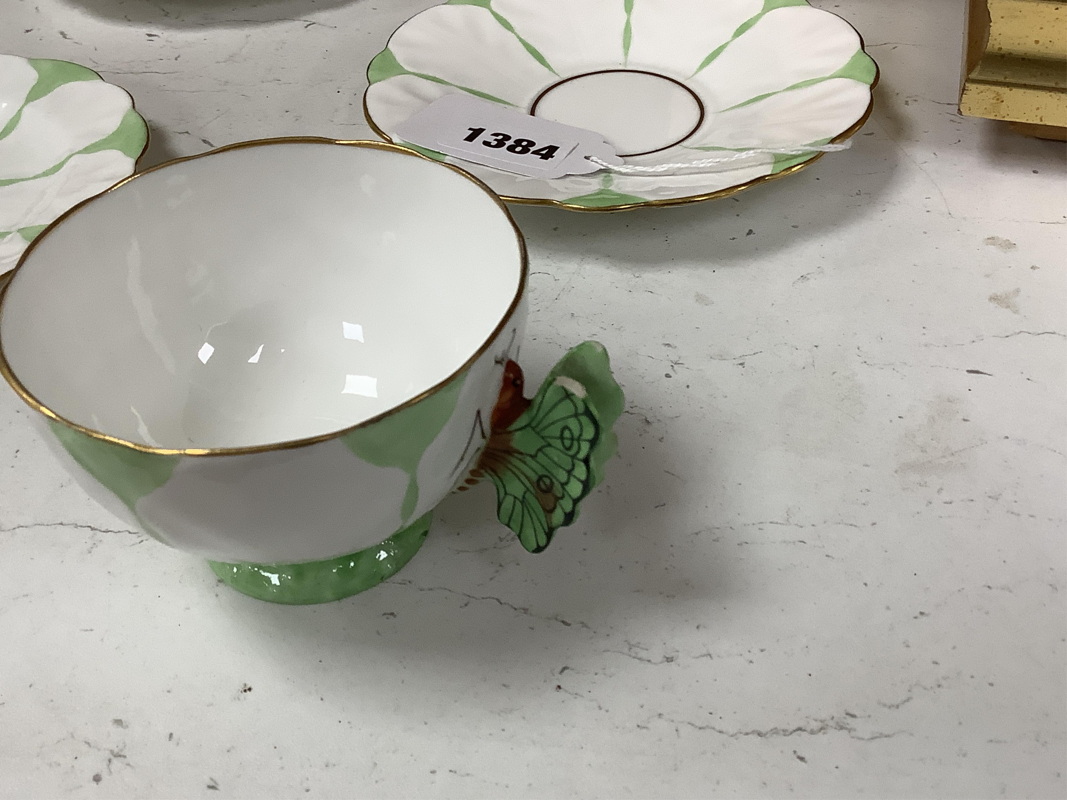 Two Aynsley trios with butterfly handles and one extra saucer, numbered 785788